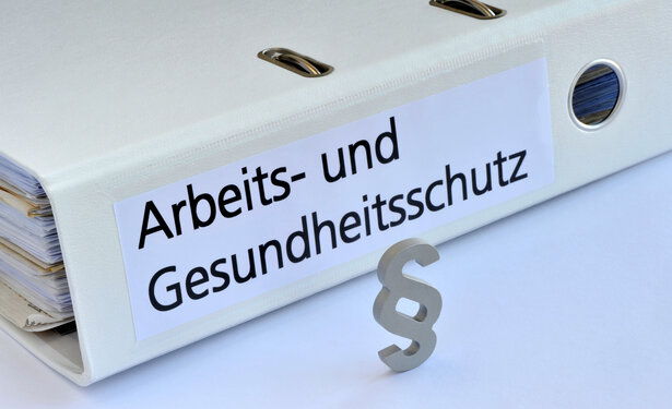 Ein weißer Ordner trägt die schwarze Aufsicht Arbeits- und Gesundheitsschutz