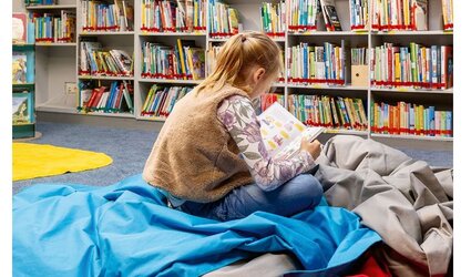 Ein Mädchen sitzt auf dem Fußboden und liest