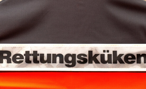 Auf dem Rücken einer orangen Warnweste steht das Wort "Rettungsküken"