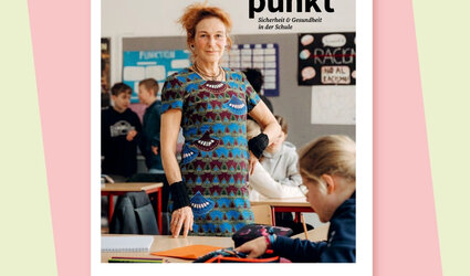 Eine Frau steht im Klassenraum vor einem Tisch