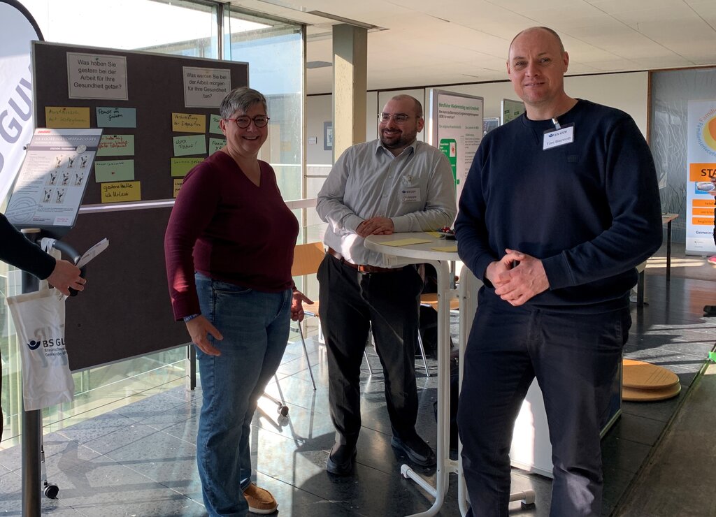 Zwei Männer und eine Frau am Stehtisch