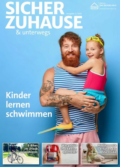 Titelseite des Magazins: Ein bärtiger rothaariger Mann mit tätowiertem Arm hält ein Mädchen im Arm. Diese hat eine Taucherbrille auf und Schwimmflossen an