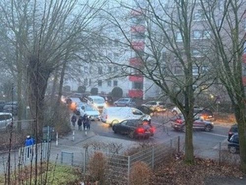 Eltern bringen ihre Kinder mit dem Auto zur Schule und blockieren dadurch die Straße