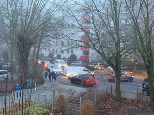 Eltern bringen ihre Kinder mit dem Auto zur Schule und blockieren dadurch die Straße